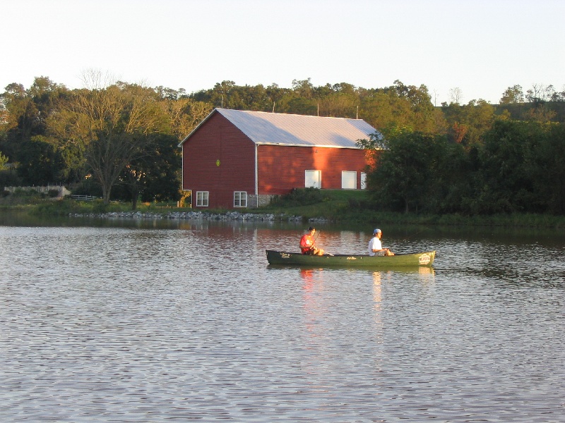 Fishing near red barn/rock bed